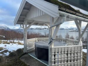 a white gazebo with snow on the ground at Centrally Located Cabin by the Sea - Sortland in Sortland
