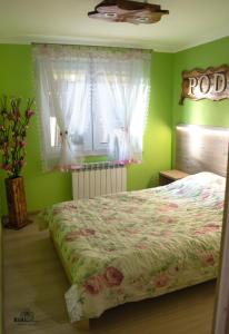 a bedroom with a bed and a window with curtains at Apartament Pod Górką Gołdap II in Gołdap