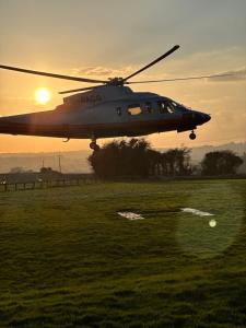 a helicopter flying over a field at sunset at Charingworth Manor in Chipping Campden