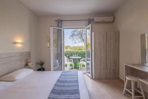 a bedroom with a bed and a door to a patio at Aria in Lakíthra