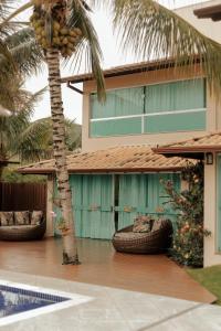 een huis met een palmboom ervoor bij Pousada Kanto Suites & Spa in Capitólio