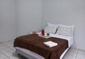 a bedroom with a bed with two towels on it at Casa da Iná! Com piscina e churrasqueira! in Rio Verde