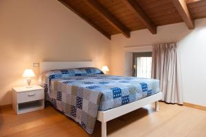 una camera con un letto blu e bianco e una finestra di Agriturismo Le Tre Rose - Cantina Zanello a Rosignano Monferrato