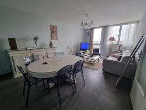 sala de estar con mesa, sillas y sofá en Panorama Lillois, Concierge-City, en La Madeleine