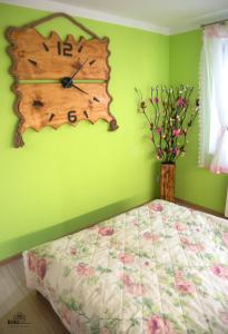 a bedroom with a clock on a green wall at Apartament Pod Górką Gołdap II in Gołdap