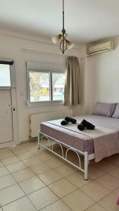 a bedroom with a bed with two black shoes on it at Elena Rooms-Apartments -B in Asprovalta