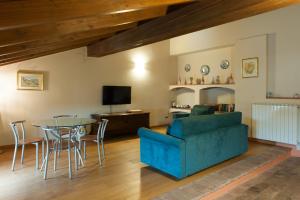 un soggiorno con un divano blu e un tavolo di Agriturismo Le Tre Rose - Cantina Zanello a Rosignano Monferrato