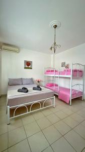 a bedroom with two bunk beds with pink accents at Elena Rooms-Apartments -B in Asprovalta