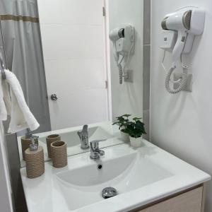uma casa de banho com um lavatório branco e um espelho. em Departamento en Avda. Colón Talcahuano em Talcahuano