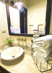 W łazience znajduje się umywalka, lustro i ręczniki. w obiekcie Fincas Panaca Herreria 26 w mieście Quimbaya