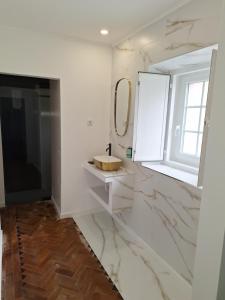 bagno bianco con lavandino e specchio di Penaferrim Sintra Rooms a Sintra