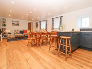 a kitchen and living room with a table and chairs at The Byre in Hexham