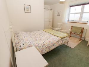a small bedroom with a bed and a chair at The Byre in Hexham