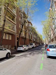a street with cars parked on the side of the road at Cuore Bernabeu in Madrid
