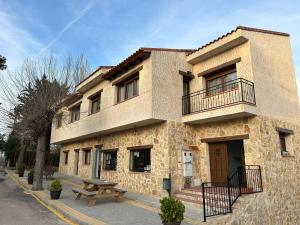 a building with a picnic table in front of it at La Posada del Pueblo in Arbancón