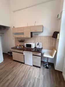 a small kitchen with a sink and a microwave at Sunshine flat at the BLAHA in Budapest