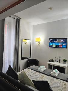 a bedroom with two beds and a tv on the wall at Hotel Max in Rome