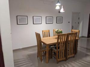 a dining room table and chairs with flowers on it at Casa Feliz - Stylish 2 Bedroom Apartment in Addis Ababa