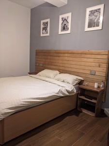 a bedroom with a bed with a wooden headboard at Casa Feliz - Stylish 2 Bedroom Apartment in Addis Ababa