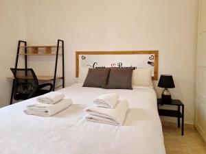 Un dormitorio con una cama blanca con toallas. en Cuore Bernabeu, en Madrid