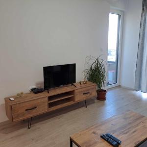 un soggiorno con TV a schermo piatto su un centro di intrattenimento in legno di Apartment B&S a Skopje