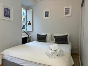 een slaapkamer met 2 bedden en handdoeken bij Amazing Apolônia in Lissabon