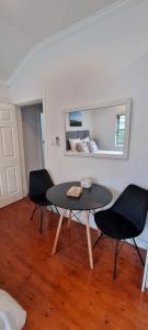 a dining room with a table and two chairs at Three Little Birds Guesthouse in Durban