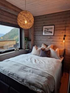 sypialnia z dużym łóżkiem i oknem w obiekcie Ny, eksklusiv hytte til leie på Voss w mieście Skulestadmo