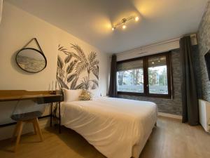 Schlafzimmer mit einem Bett, einem Schreibtisch und einem Fenster in der Unterkunft Studios & chambres aux portes de Genève in Saint-Julien-en-Genevois