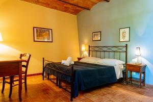 a bedroom with a bed and a table and a desk at Villa Le Beringhe - Wine Pool & Relax in Colle Val D'Elsa