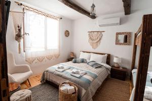 een slaapkamer met een bed, een stoel en een raam bij Вила Китна in Kyustendil