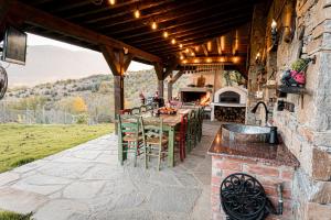 an outdoor kitchen with a table and chairs on a patio at Вила Китна in Kyustendil