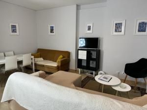 een woonkamer met een bank en een tv bij Amazing Apolônia in Lissabon