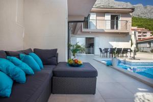 バシュカ・ヴォダにあるLuxury Villa Rogacのスイミングプールの隣のパティオ(ソファ付) +34枚の写真