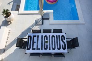 バシュカ・ヴォダにあるLuxury Villa Rogacの椅子と看板のあるプールの上空からの眺め