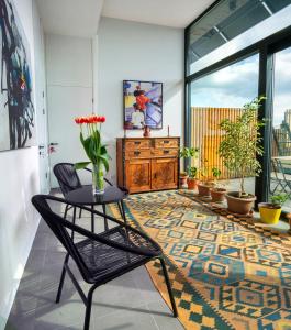 een woonkamer met een tafel en stoelen op een tapijt bij Erkan Alek Heritage Hotel in Gjoemri