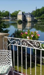a bench with flowers on it next to a body of water at Villa du Loir in La Flèche
