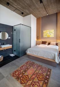 a bedroom with a large bed and a bathroom at Erkan Alek Heritage Hotel in Gyumri