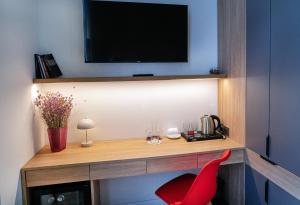 a living room with a red chair and a television at Erkan Alek Heritage Hotel in Gyumri
