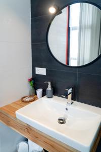 a bathroom with a white sink and a mirror at Erkan Alek Heritage Hotel in Gyumri