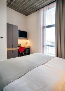 a bedroom with a bed and a desk and a window at Erkan Alek Heritage Hotel in Gyumri