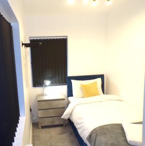 una piccola camera con letto e finestra di Hazelhurst House - 4 bedrooms 2 bathrooms a Stoke on Trent