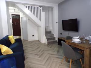 un soggiorno con divano blu e TV di Hazelhurst House - 4 bedrooms 2 bathrooms a Stoke on Trent