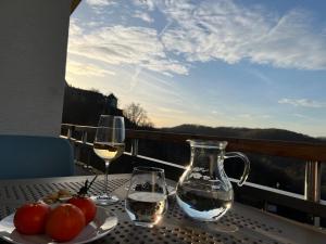 einen Tisch mit zwei Gläsern Wein auf dem Balkon in der Unterkunft Fi-Suiten in Waldeck