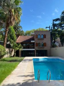 a swimming pool in front of a house at CASA ALMA LUXURY HOME in Mendoza