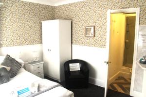 a bedroom with a bed and a chair at Serena Court Hotel in Skegness