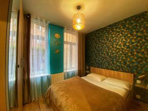 een slaapkamer met een bed en een blauwe muur bij Le nid du Quai by Concierge City in Lille