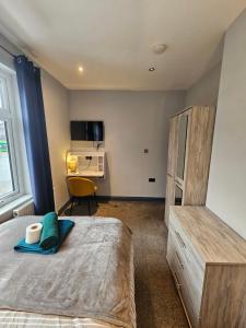 a bedroom with a bed and a desk in it at Tudor Road House in Leicester