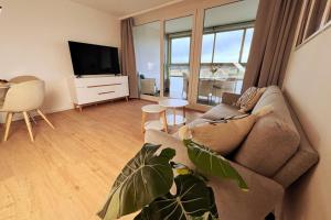 a living room with a couch and a flat screen tv at Apartment mit Weitblick in Löffingen