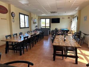 a dining room with wooden tables and chairs at Albergue Valmadrid in Valmadrid
